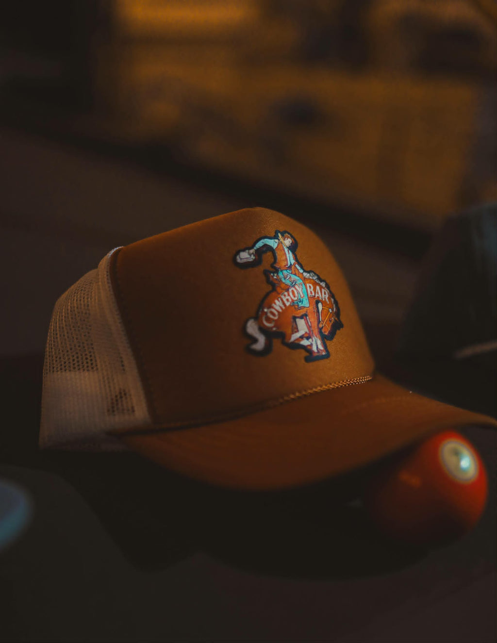 Rust western trucker cap with cowboy bar bucking horse, cream mesh back and vintage county inspired design