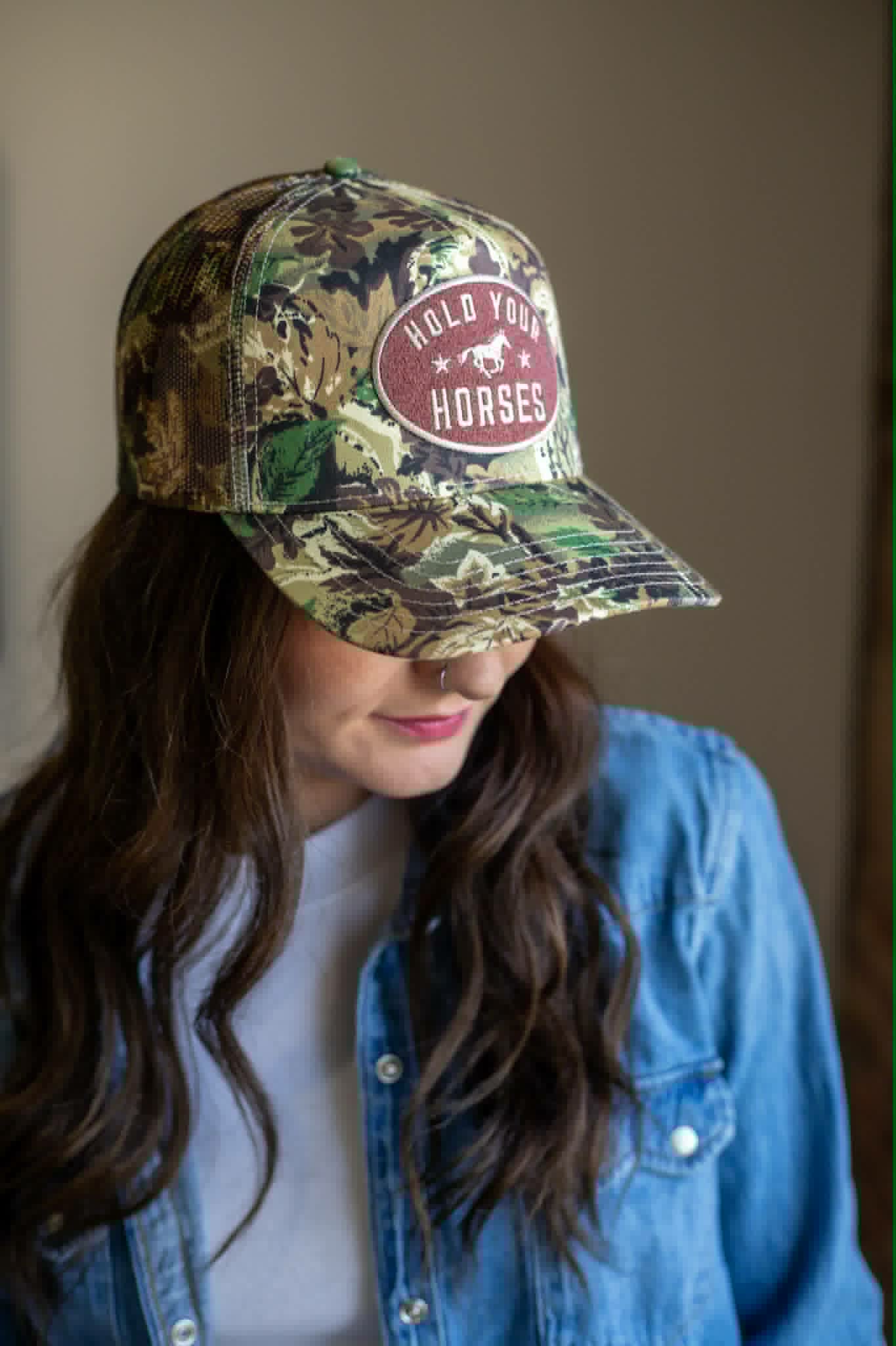 Western Camo trucker hat with chocolate coloured pacth with gold embroidery saying HOLD YOUR HORSES