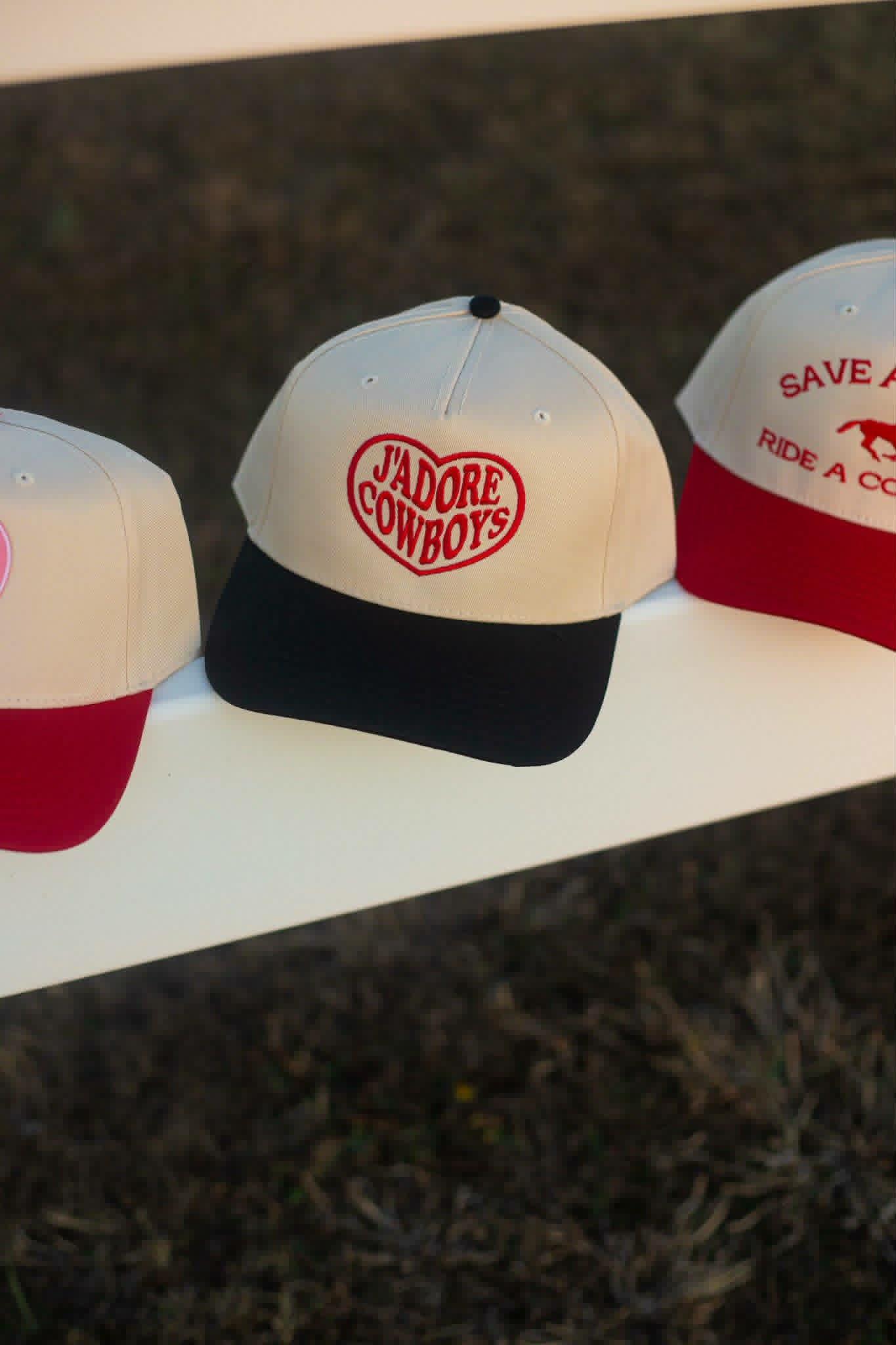 Western Cream trucker cap with black brim and red heart with "J" Adore Cowboys