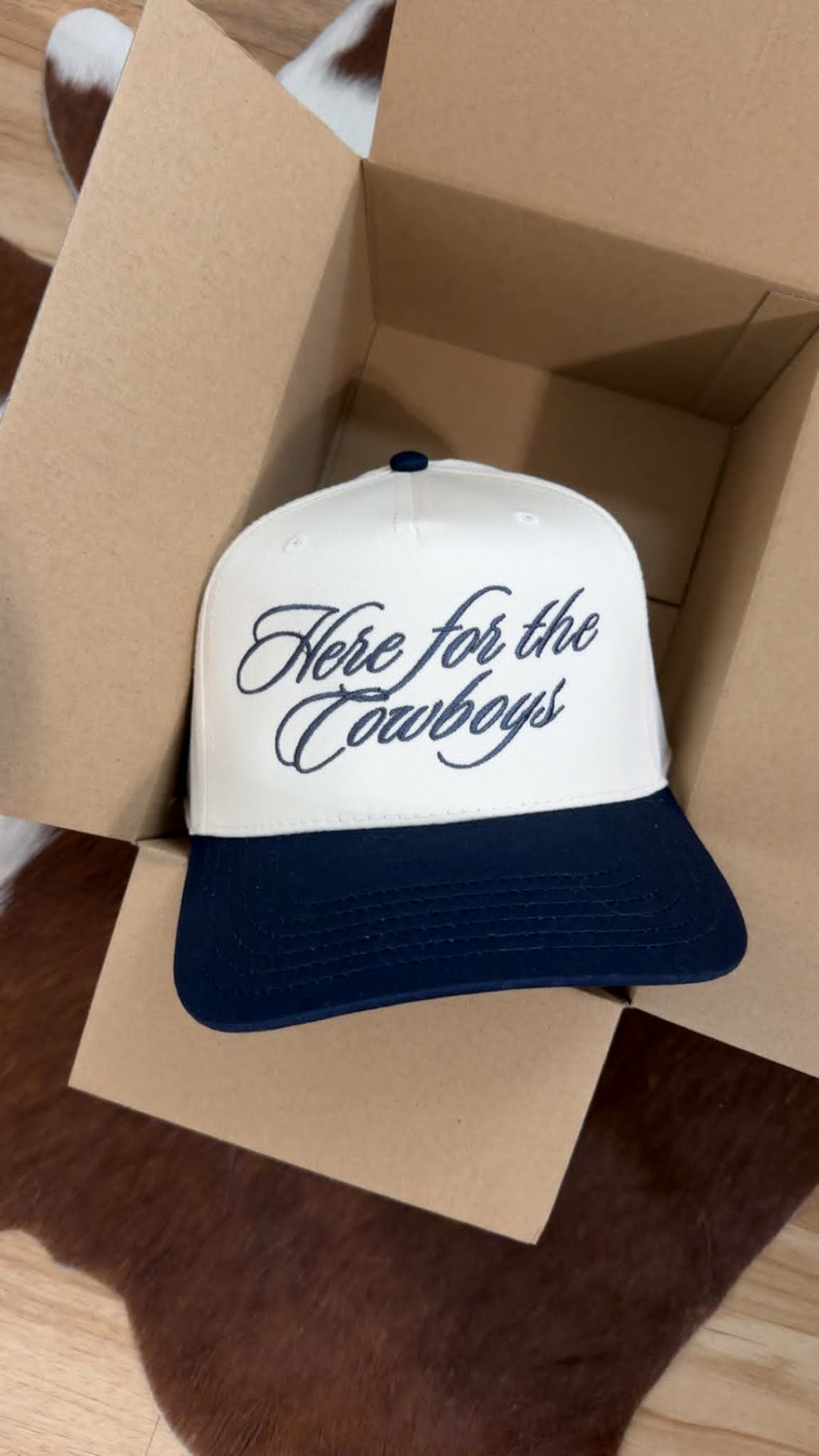 western trucker cap white and navy trucker cap with a structured front panel featuring cursive script that reads " Here for The Cowboys" the cap has a navy curved brim
